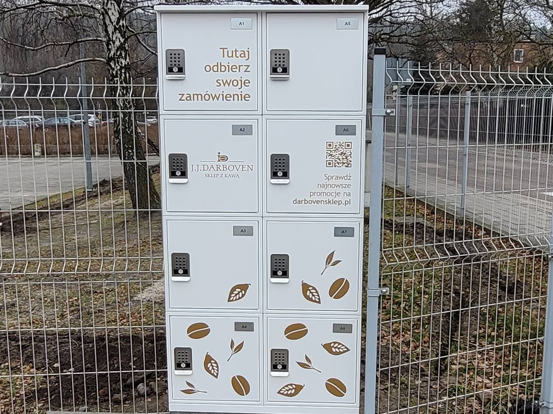 Biały automat Click & Collect Pakomatic z brandingiem J.J. Darboven przy sklepie